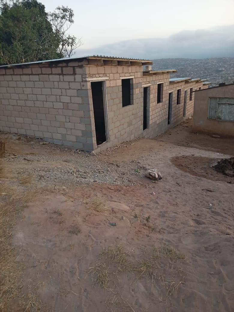 Row of block-built units with roof structure and sheeting installed